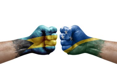 Two hands punch to each others on white background. Country flags painted fists, conflict crisis concept between bahamas and solomon islands