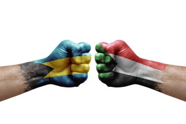 Two hands punch to each others on white background. Country flags painted fists, conflict crisis concept between bahamas and sudan