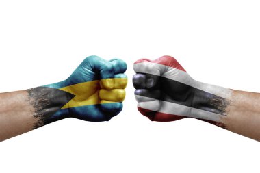 Two hands punch to each others on white background. Country flags painted fists, conflict crisis concept between bahamas and thailand