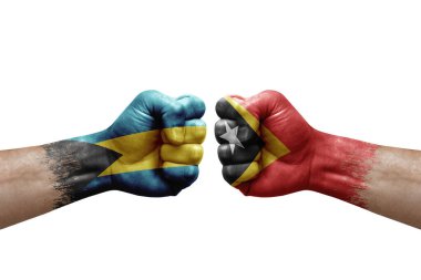 Two hands punch to each others on white background. Country flags painted fists, conflict crisis concept between bahamas and timor leste