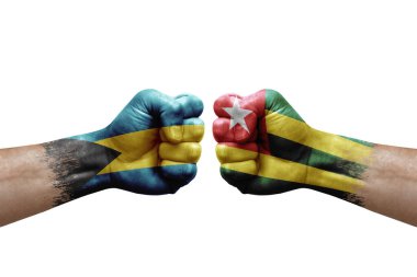 Two hands punch to each others on white background. Country flags painted fists, conflict crisis concept between bahamas and togo