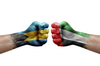 Two hands punch to each others on white background. Country flags painted fists, conflict crisis concept between bahamas and united arab emirates