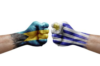 Two hands punch to each others on white background. Country flags painted fists, conflict crisis concept between bahamas and uruguay