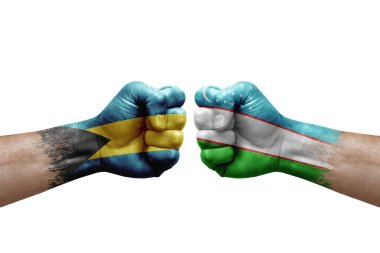 Two hands punch to each others on white background. Country flags painted fists, conflict crisis concept between bahamas and uzbekistan