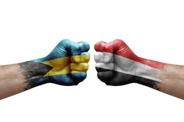 Two hands punch to each others on white background. Country flags painted fists, conflict crisis concept between bahamas and yemen