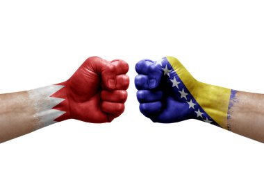 Two hands punch to each others on white background. Country flags painted fists, conflict crisis concept between bahrain and bosnia