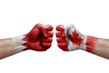 Two hands punch to each others on white background. Country flags painted fists, conflict crisis concept between bahrain and canada