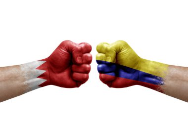 Two hands punch to each others on white background. Country flags painted fists, conflict crisis concept between bahrain and colombia
