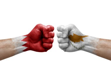Two hands punch to each others on white background. Country flags painted fists, conflict crisis concept between bahrain and cyprus