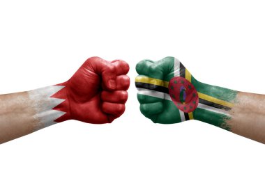 Two hands punch to each others on white background. Country flags painted fists, conflict crisis concept between bahrain and dominica
