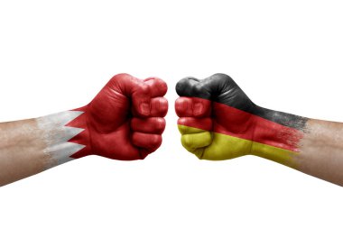 Two hands punch to each others on white background. Country flags painted fists, conflict crisis concept between bahrain and germany