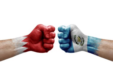Two hands punch to each others on white background. Country flags painted fists, conflict crisis concept between bahrain and guatemala