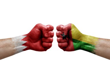 Two hands punch to each others on white background. Country flags painted fists, conflict crisis concept between bahrain and guinea-bissau