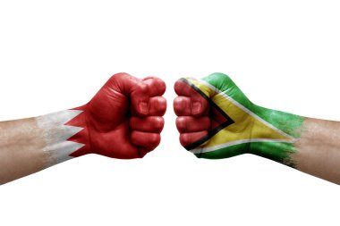 Two hands punch to each others on white background. Country flags painted fists, conflict crisis concept between bahrain and guyana