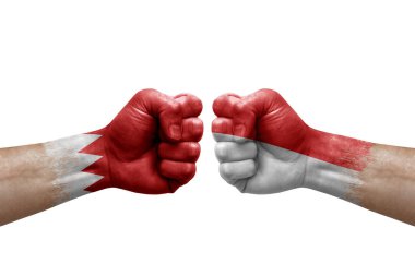 Two hands punch to each others on white background. Country flags painted fists, conflict crisis concept between bahrain and indonesia
