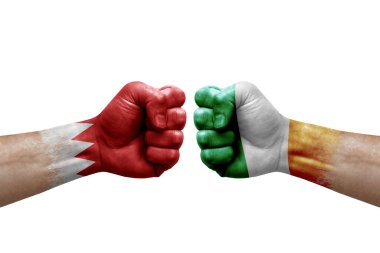 Two hands punch to each others on white background. Country flags painted fists, conflict crisis concept between bahrain and ireland