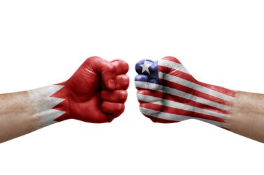 Two hands punch to each others on white background. Country flags painted fists, conflict crisis concept between bahrain and liberia