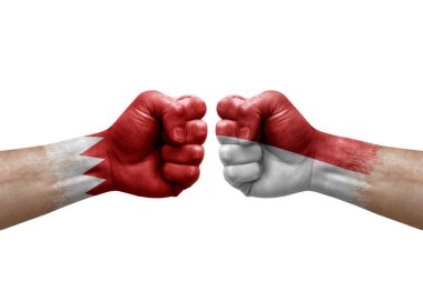 Two hands punch to each others on white background. Country flags painted fists, conflict crisis concept between bahrain and monaco