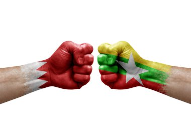 Two hands punch to each others on white background. Country flags painted fists, conflict crisis concept between bahrain and myanmar