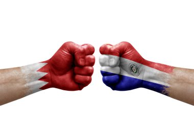 Two hands punch to each others on white background. Country flags painted fists, conflict crisis concept between bahrain and paraguay