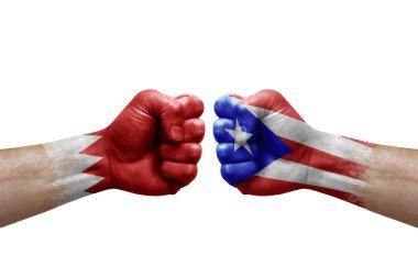 Two hands punch to each others on white background. Country flags painted fists, conflict crisis concept between bahrain and puerto rico