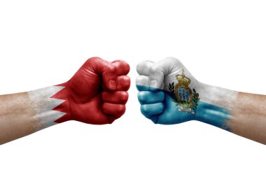 Two hands punch to each others on white background. Country flags painted fists, conflict crisis concept between bahrain and san marino