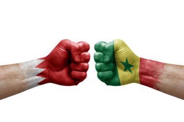 Two hands punch to each others on white background. Country flags painted fists, conflict crisis concept between bahrain and senegal