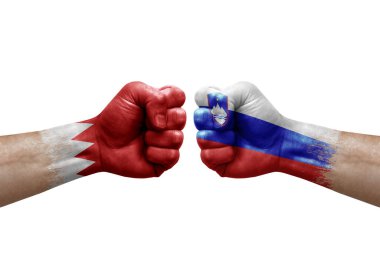 Two hands punch to each others on white background. Country flags painted fists, conflict crisis concept between bahrain and slovenia