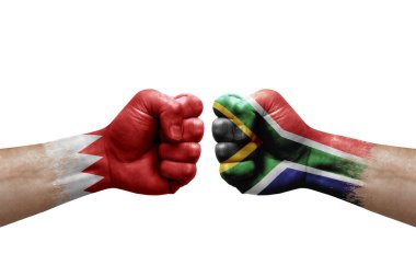 Two hands punch to each others on white background. Country flags painted fists, conflict crisis concept between bahrain and south africa