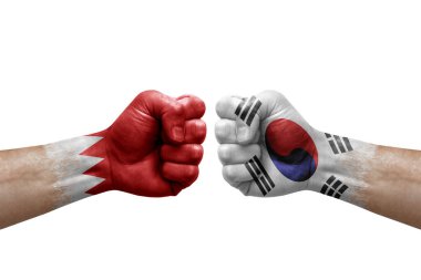 Two hands punch to each others on white background. Country flags painted fists, conflict crisis concept between bahrain and south korea