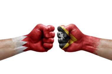Two hands punch to each others on white background. Country flags painted fists, conflict crisis concept between bahrain and timor leste