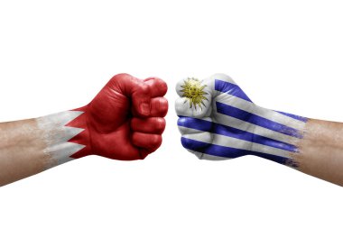 Two hands punch to each others on white background. Country flags painted fists, conflict crisis concept between bahrain and uruguay