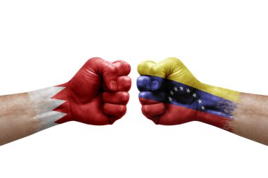Two hands punch to each others on white background. Country flags painted fists, conflict crisis concept between bahrain and venezuela