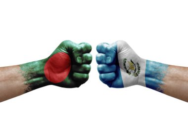 Two hands punch to each others on white background. Country flags painted fists, conflict crisis concept between bangladesh and guatemala