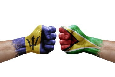 Two hands punch to each others on white background. Country flags painted fists, conflict crisis concept between barbados and guyana