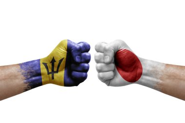 Two hands punch to each others on white background. Country flags painted fists, conflict crisis concept between barbados and japan