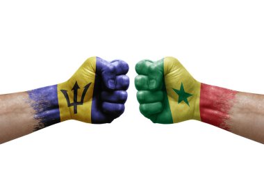 Two hands punch to each others on white background. Country flags painted fists, conflict crisis concept between barbados and senegal