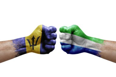 Two hands punch to each others on white background. Country flags painted fists, conflict crisis concept between barbados and sierra leone