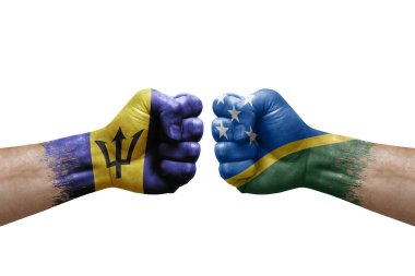Two hands punch to each others on white background. Country flags painted fists, conflict crisis concept between barbados and solomon islands