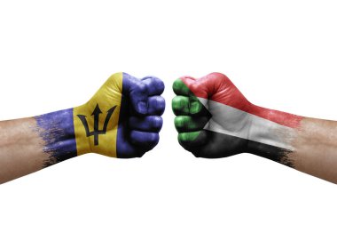 Two hands punch to each others on white background. Country flags painted fists, conflict crisis concept between barbados and sudan