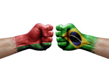 Two hands punch to each others on white background. Country flags painted fists, conflict crisis concept between belarus and brazil