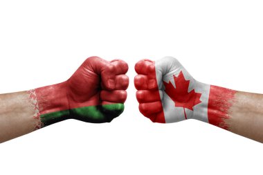 Two hands punch to each others on white background. Country flags painted fists, conflict crisis concept between belarus and canada