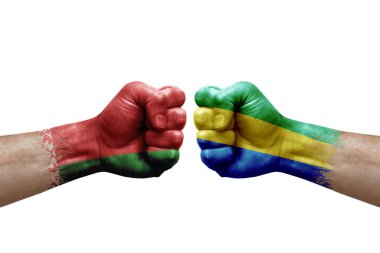 Two hands punch to each others on white background. Country flags painted fists, conflict crisis concept between belarus and gabon