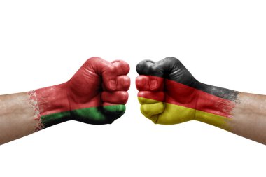 Two hands punch to each others on white background. Country flags painted fists, conflict crisis concept between belarus and germany