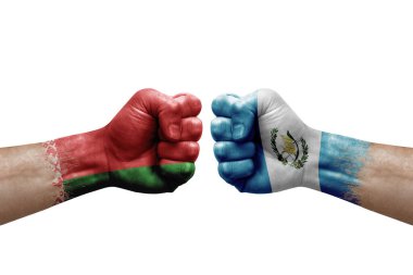 Two hands punch to each others on white background. Country flags painted fists, conflict crisis concept between belarus and guatemala