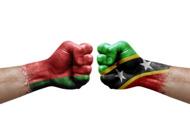 Two hands punch to each others on white background. Country flags painted fists, conflict crisis concept between belarus and saint kitts and nevis