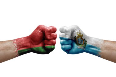 Two hands punch to each others on white background. Country flags painted fists, conflict crisis concept between belarus and san marino