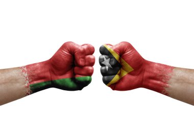 Two hands punch to each others on white background. Country flags painted fists, conflict crisis concept between belarus and timor leste