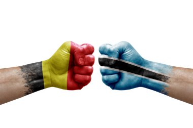 Two hands punch to each others on white background. Country flags painted fists, conflict crisis concept between belgium and botswana