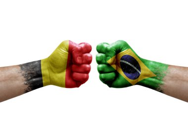 Two hands punch to each others on white background. Country flags painted fists, conflict crisis concept between belgium and brazil